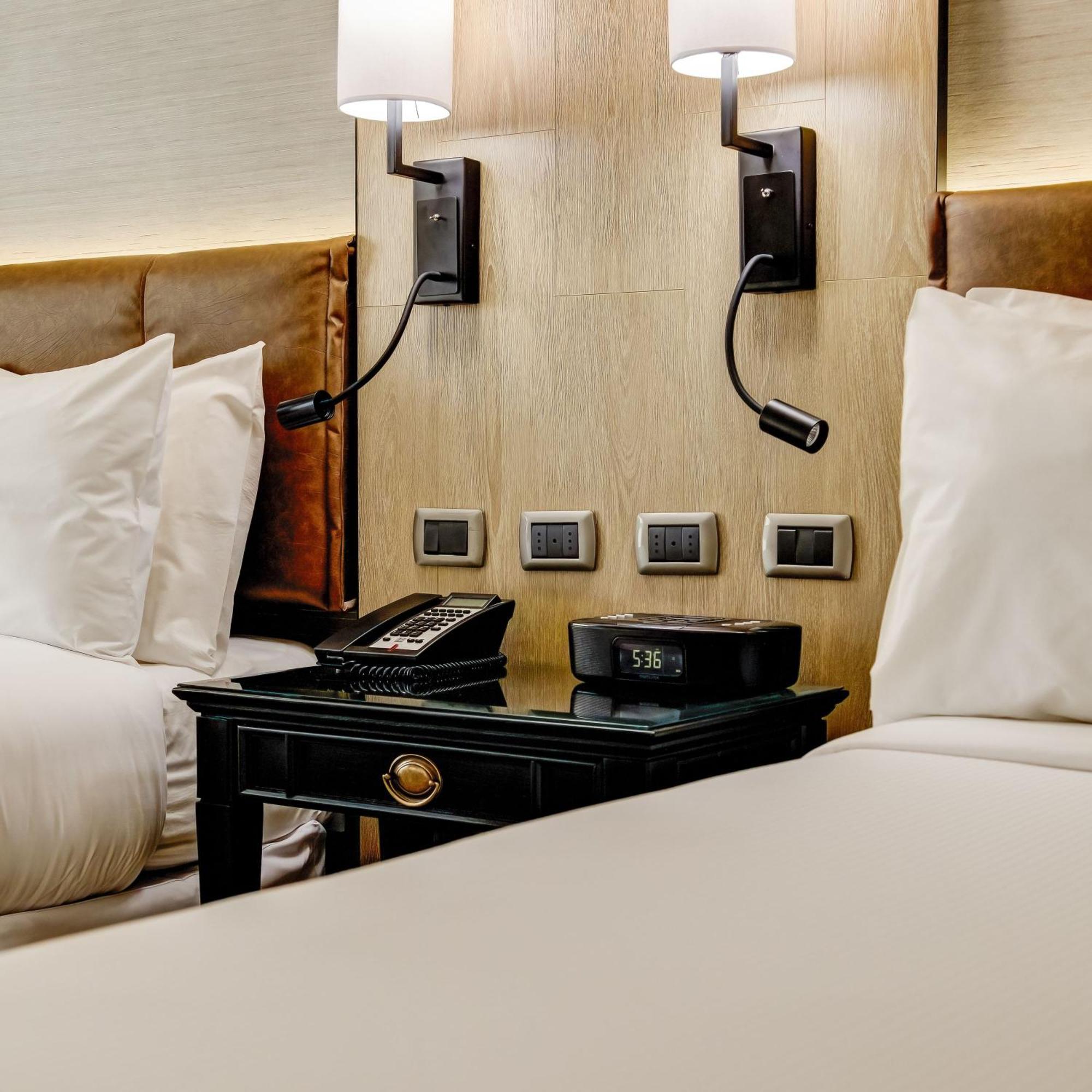Plaza El Bosque Ebro Hotel Santiago Luaran gambar A bedside table with a telephone and a digital alarm clock